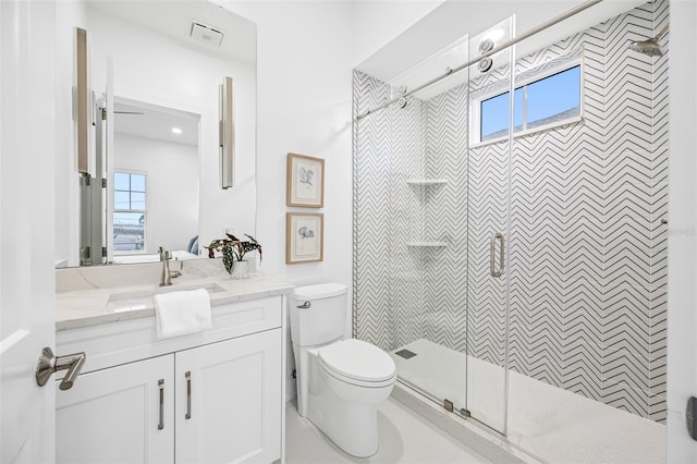 bathroom featuring vanity, toilet, and a tile shower