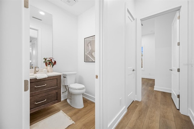 bathroom featuring hardwood / wood-style flooring, toilet, and vanity