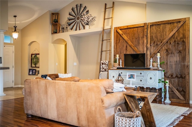 living room featuring dark wood-type flooring and high vaulted ceiling