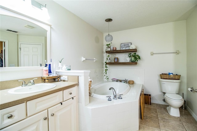 bathroom featuring tiled bath, vanity, toilet, tile patterned floors, and a textured ceiling