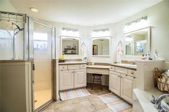 bathroom with vanity, a shower with door, and a textured ceiling