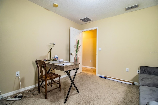 carpeted office with a textured ceiling