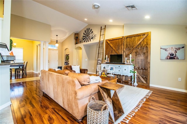 living room featuring ornate columns, dark wood-type flooring, and high vaulted ceiling