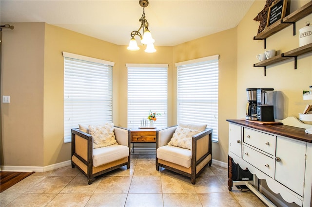 living area featuring light tile patterned flooring, a healthy amount of sunlight, and a notable chandelier