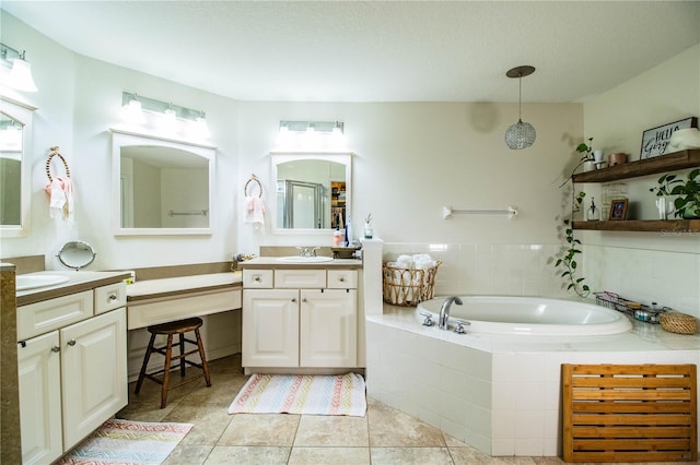 bathroom with a relaxing tiled tub, tile patterned floors, and vanity