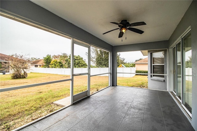 unfurnished sunroom with ceiling fan