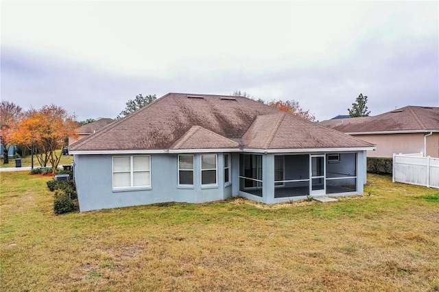 back of property with a yard and a sunroom