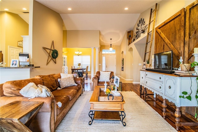living room with a chandelier, recessed lighting, high vaulted ceiling, arched walkways, and wood finished floors