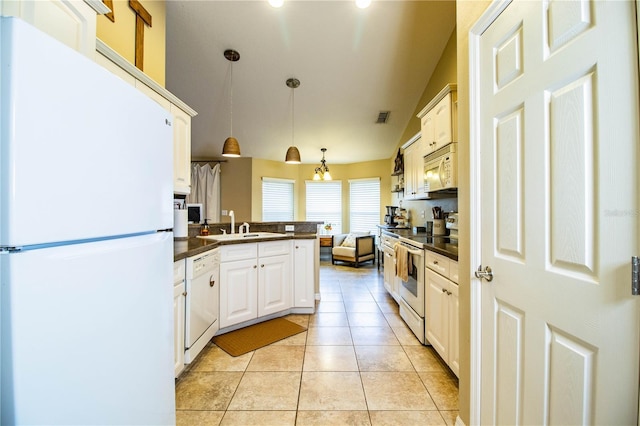 kitchen with a sink, dark countertops, white appliances, a peninsula, and light tile patterned flooring