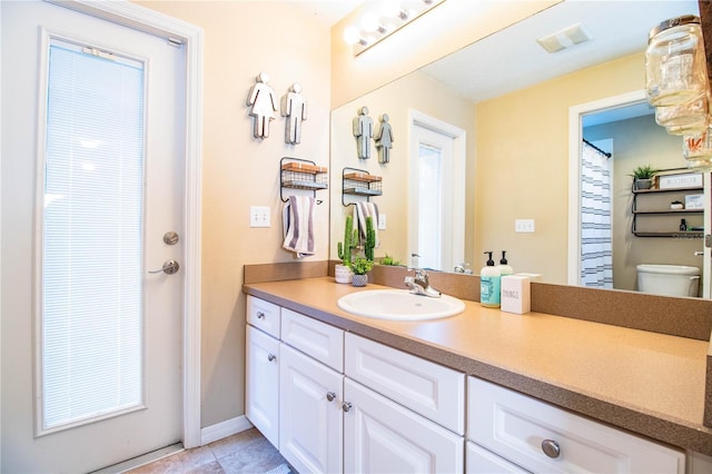 bathroom with tile patterned flooring, vanity, visible vents, and toilet