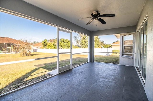 unfurnished sunroom with a ceiling fan