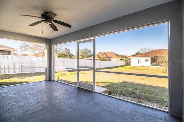 unfurnished sunroom with a ceiling fan