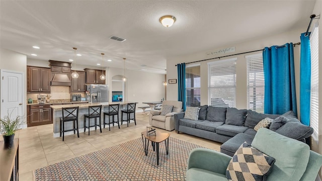 living room with a textured ceiling and light tile patterned flooring