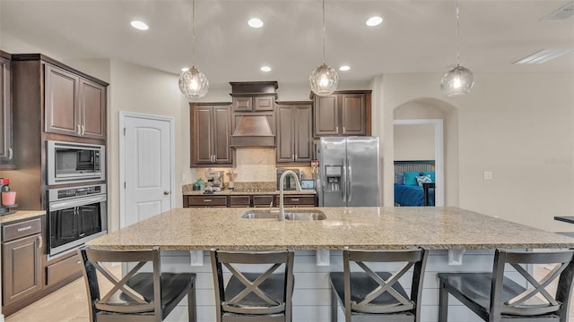 kitchen with sink, stainless steel appliances, and dark brown cabinets