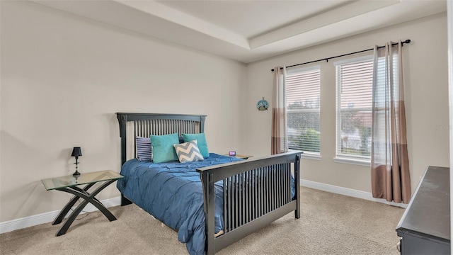 carpeted bedroom featuring a tray ceiling