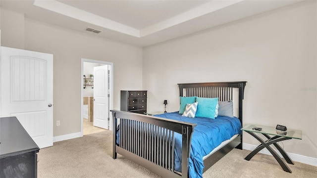 bedroom with light colored carpet and a raised ceiling