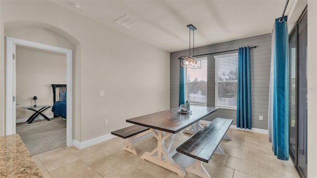 carpeted dining room featuring an inviting chandelier