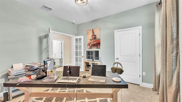 office area featuring a textured ceiling and light tile patterned floors