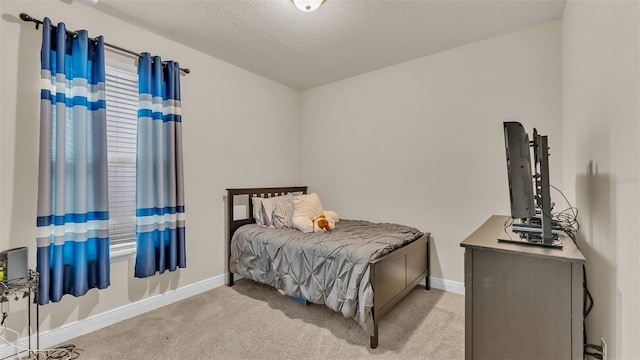 bedroom with a textured ceiling and light carpet