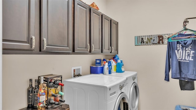 washroom featuring washing machine and clothes dryer and cabinets