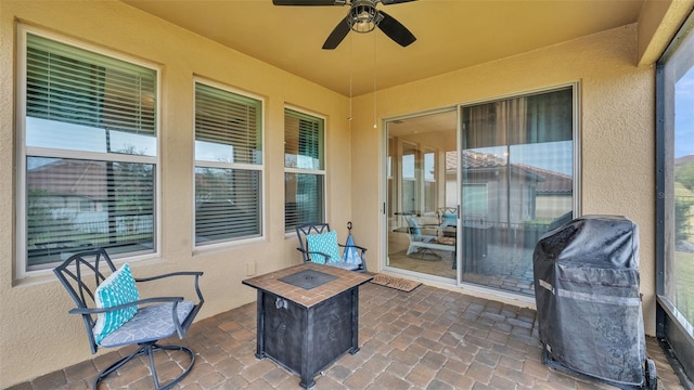 view of patio featuring ceiling fan, an outdoor fire pit, and a grill