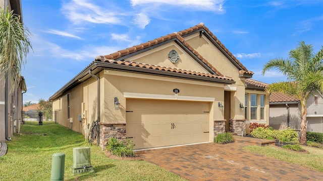 mediterranean / spanish house with a garage and a front lawn