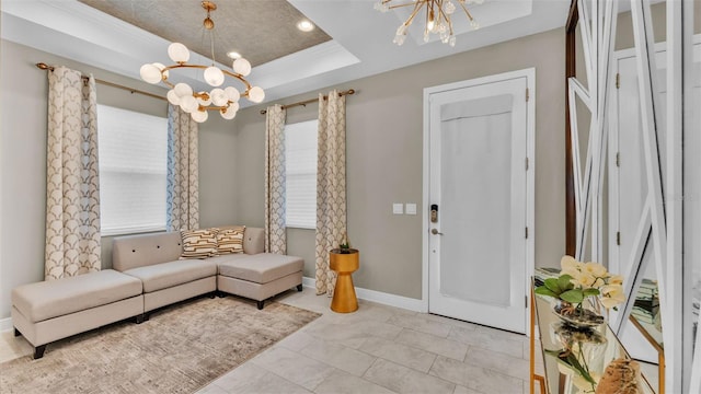 living room featuring an inviting chandelier, ornamental molding, a tray ceiling, and light tile patterned flooring