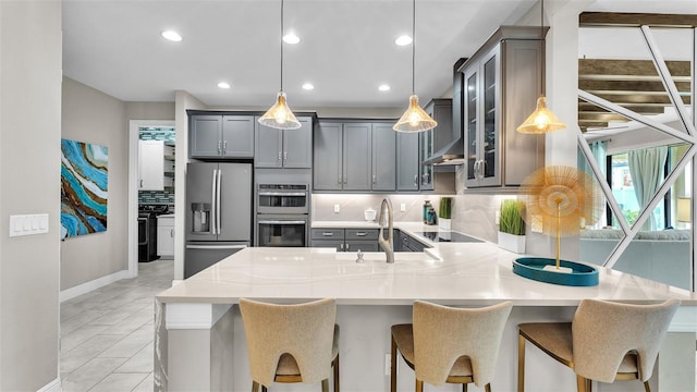 kitchen featuring tasteful backsplash, sink, decorative light fixtures, and appliances with stainless steel finishes