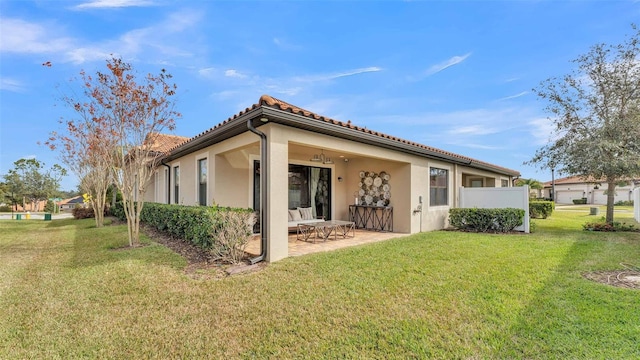 rear view of property featuring a patio area and a lawn