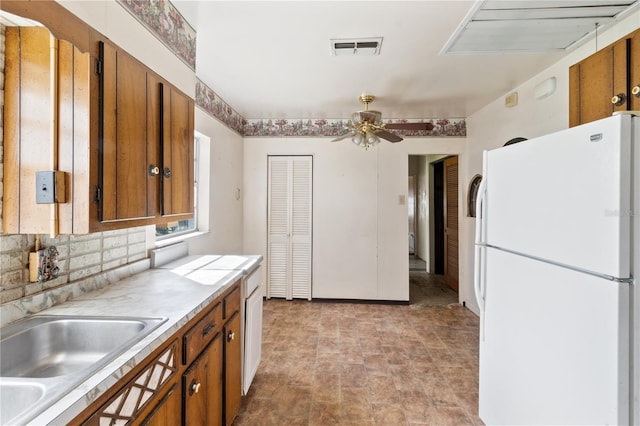 kitchen featuring white refrigerator, sink, backsplash, and ceiling fan