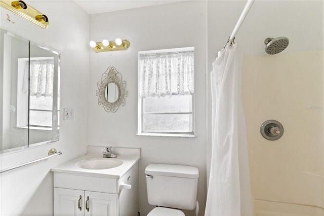 bathroom with vanity, plenty of natural light, toilet, and walk in shower