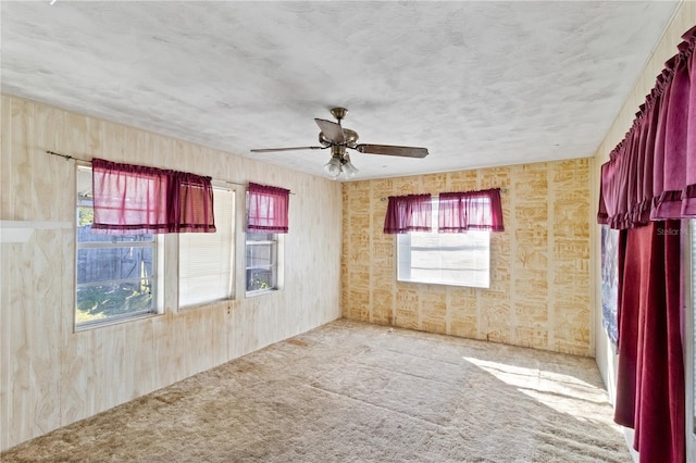 empty room with ceiling fan, carpet floors, and a healthy amount of sunlight