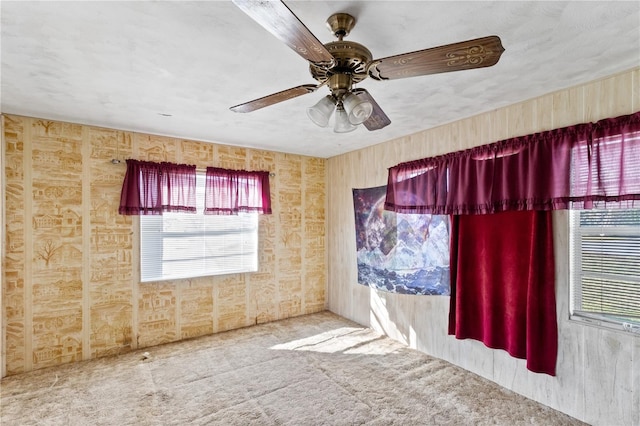 carpeted spare room featuring ceiling fan