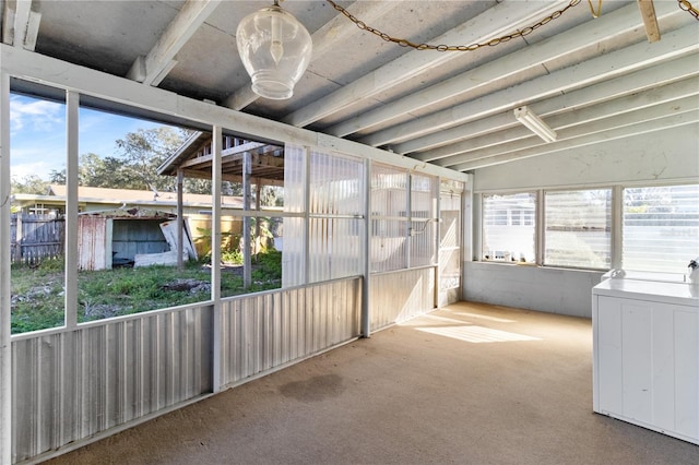 unfurnished sunroom featuring lofted ceiling and washer / clothes dryer