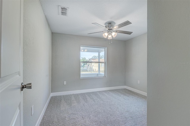 carpeted spare room featuring ceiling fan