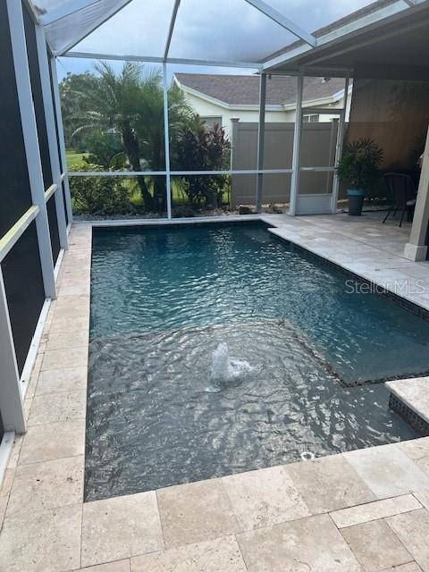 view of pool with a patio area and a lanai