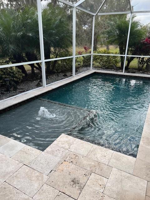 view of swimming pool featuring a lanai