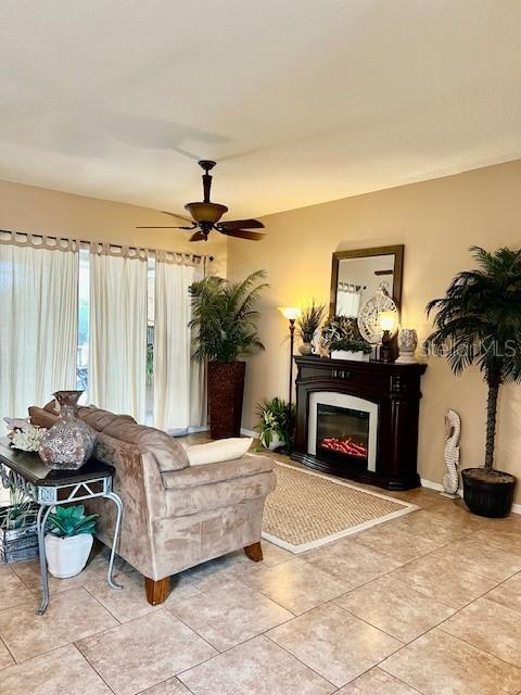 living room with light tile patterned floors and ceiling fan