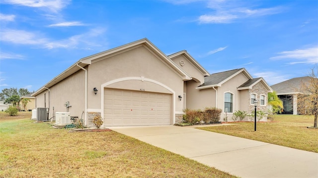 view of front of house with a front yard, central AC, and a garage