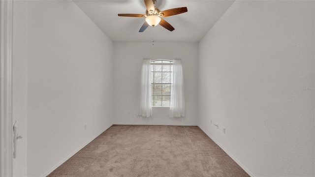 spare room with ceiling fan and light carpet