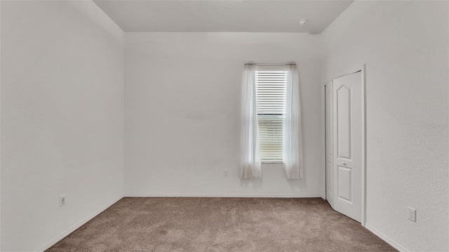 unfurnished room featuring light carpet