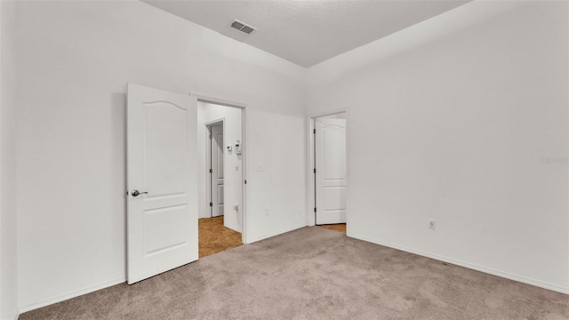 spare room featuring a textured ceiling and carpet flooring