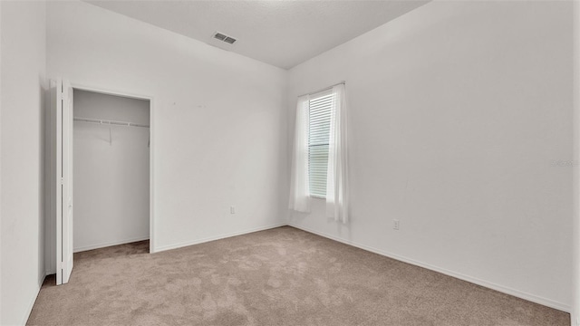 unfurnished bedroom featuring a closet and light carpet