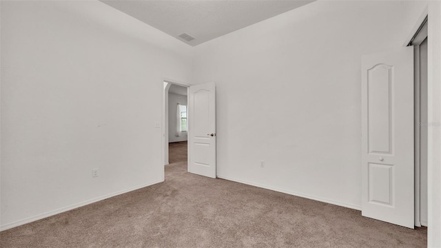 spare room featuring light colored carpet