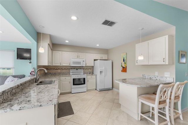 kitchen with pendant lighting, white appliances, white cabinets, sink, and kitchen peninsula