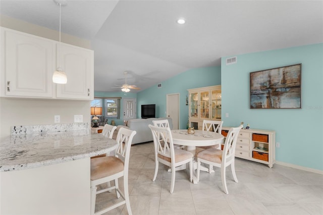 tiled dining room with ceiling fan and lofted ceiling