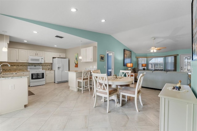 dining space featuring sink, vaulted ceiling, and ceiling fan