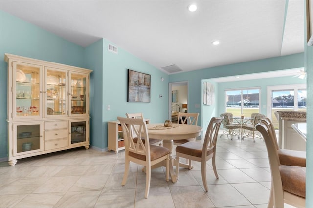 tiled dining space with vaulted ceiling and ceiling fan