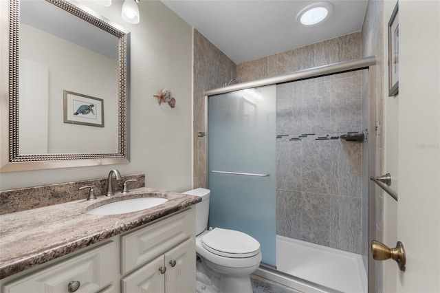 bathroom featuring vanity, toilet, and walk in shower