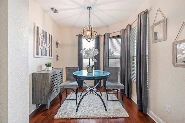 dining area featuring dark hardwood / wood-style floors and a notable chandelier